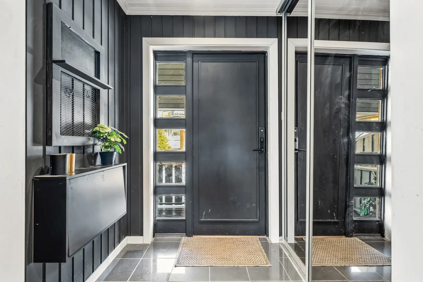 Hallen er utstyrt med innebygd skyvedørsgarderobe med speilfronter, samt himling med downlights som gir behagelig belysning. Inngangsdøren h