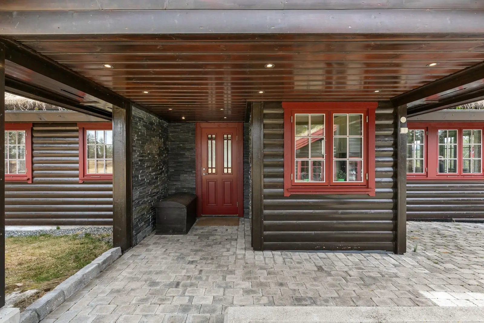 På nordsiden av hytte og anneks er det et område med plen/gressbakke.