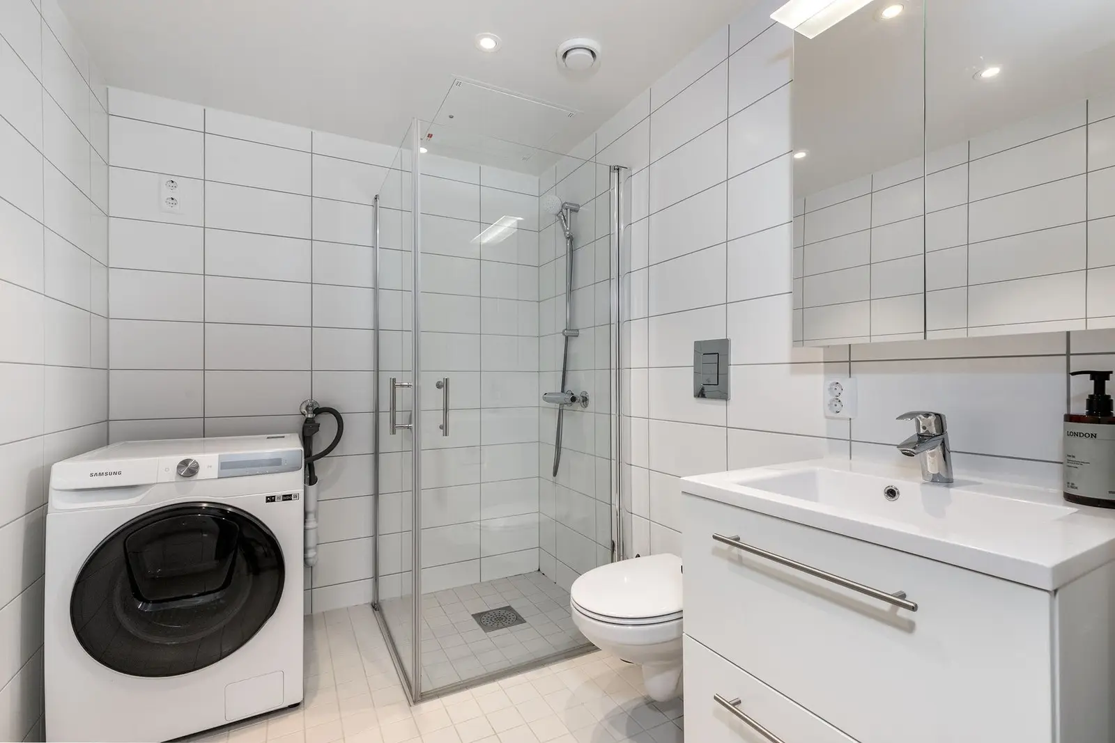 Delikat og tidsriktig bad med flislagte overflater og et rent, tiltalende uttrykk. Badet er innredet med vegghengt servantskap med heldekken