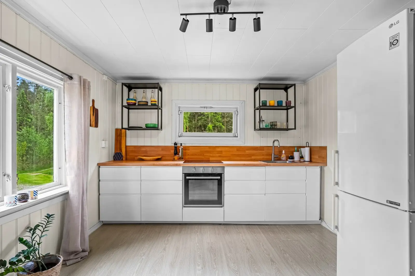 Kjøkkeninnredning i 2020 fra IKEA med hvite slette fronter og laminat benkeplate med nedfelt kum og ett-greps blandebatteri.