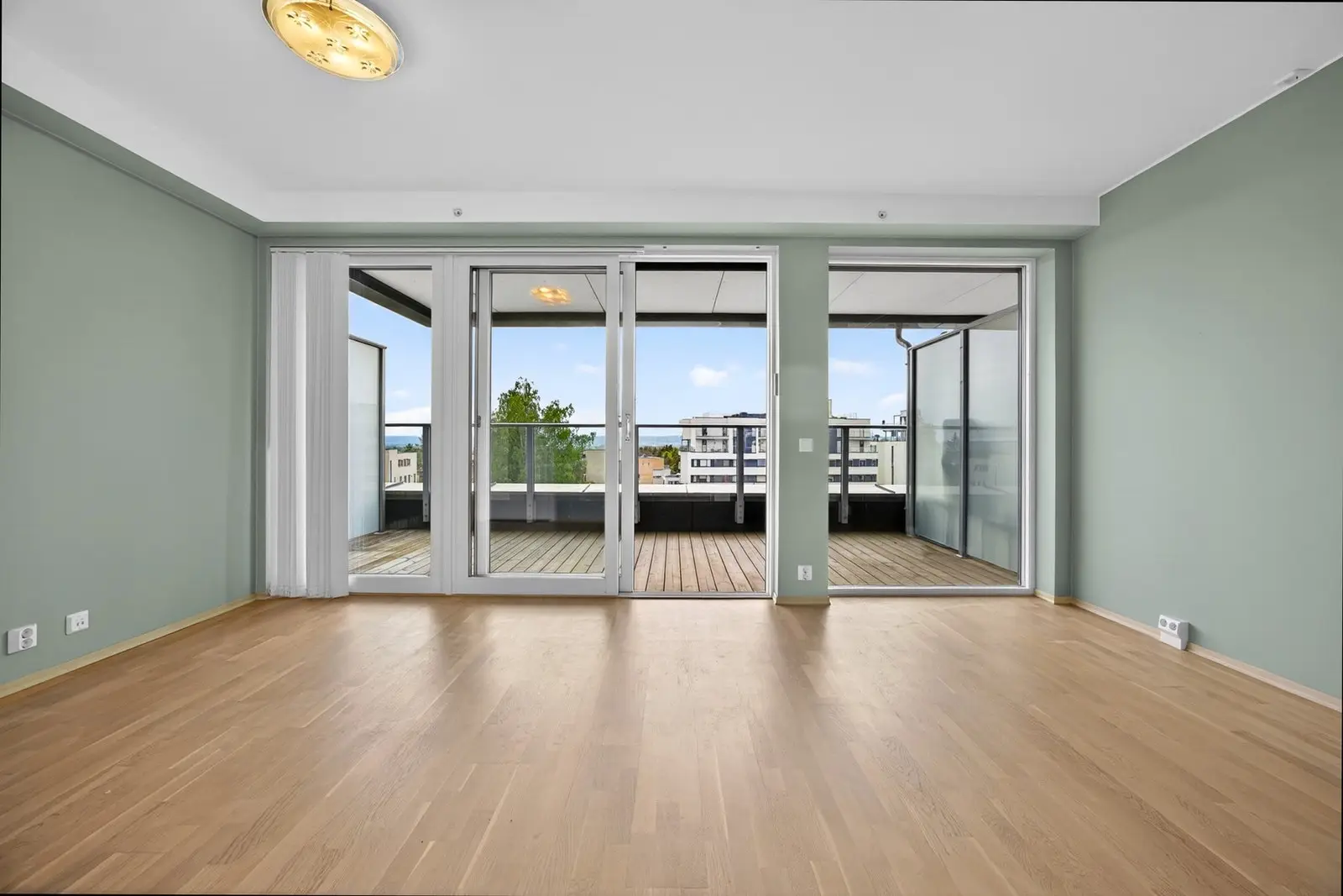 Fra stuen er det utgang til en balkong på 14 kvm med terrassebord og rekkverk i metall og glass, som gir et lett og moderne uttrykk mot uter