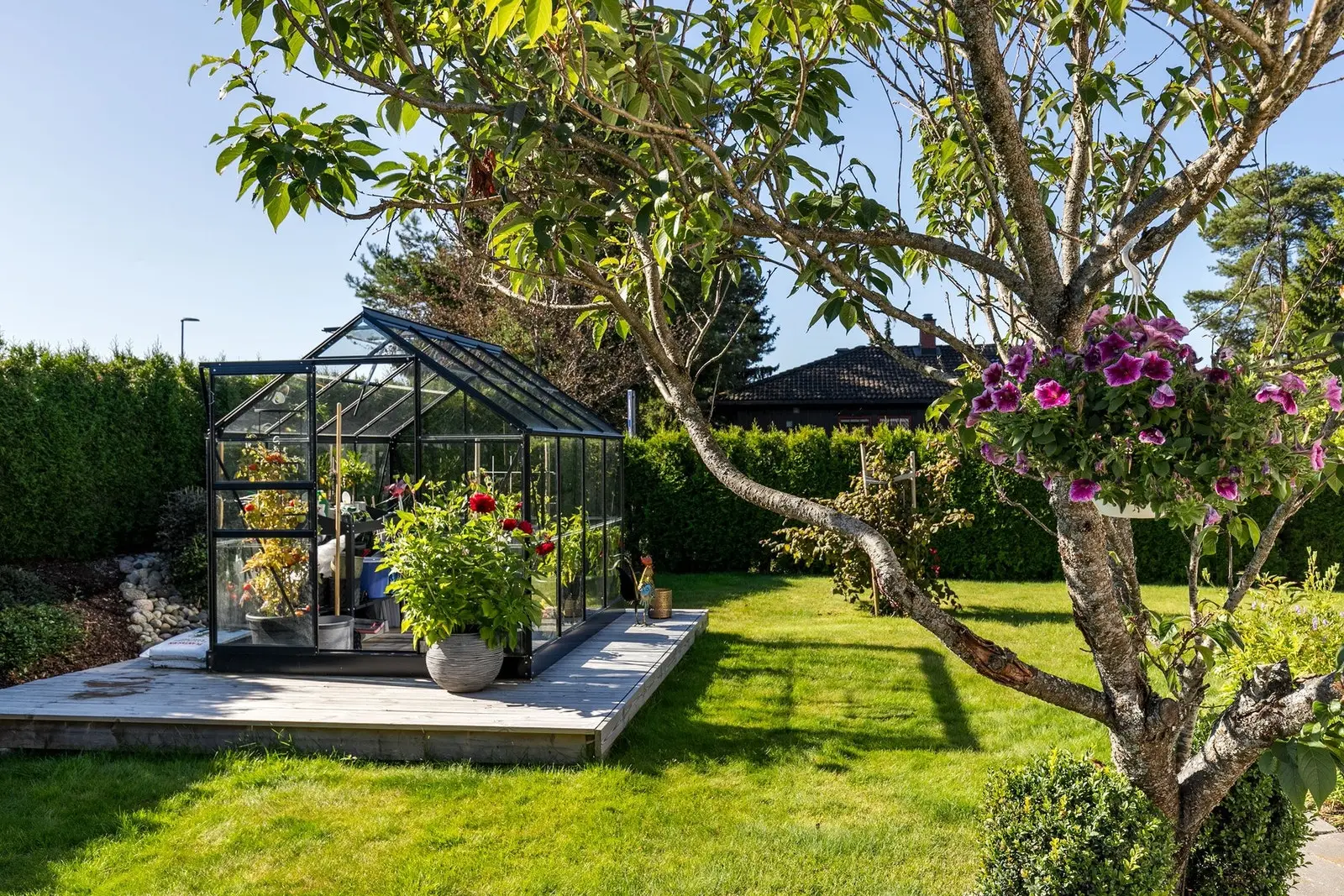 Eiendommen har en pent opparbeidet og lettstelt tomt, innrammet av en frodig og veletablert tujahekk.