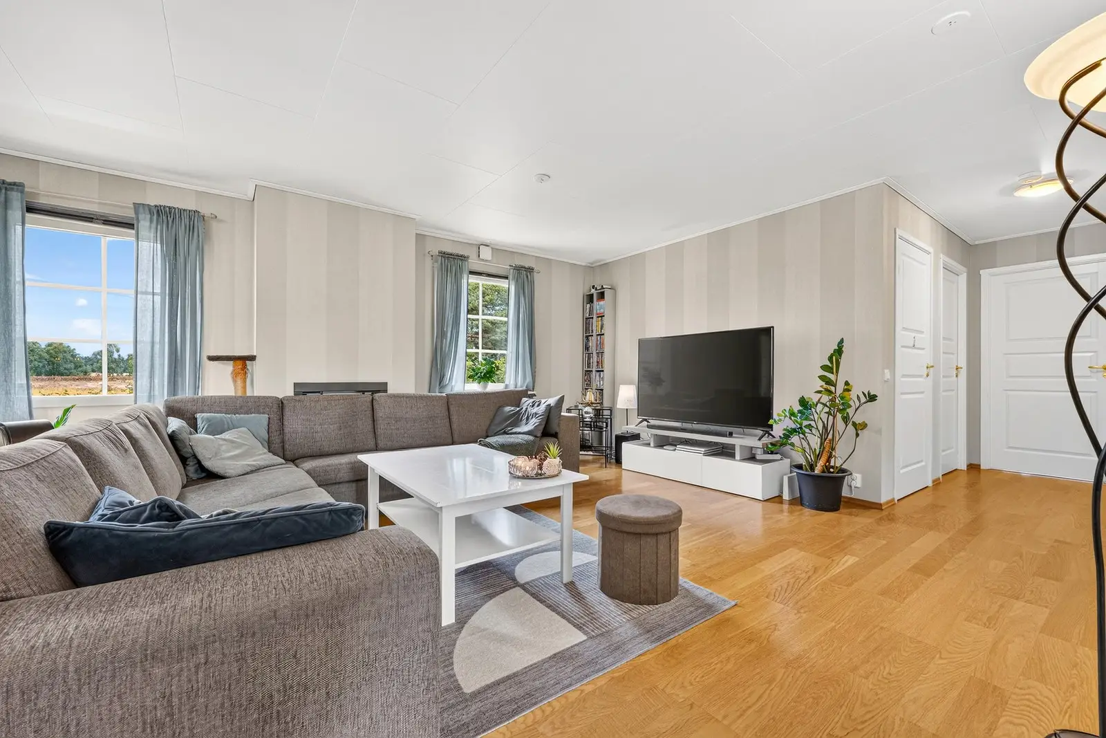 Her er det god plass til en romslig sofagruppe med tilhørende møblement.