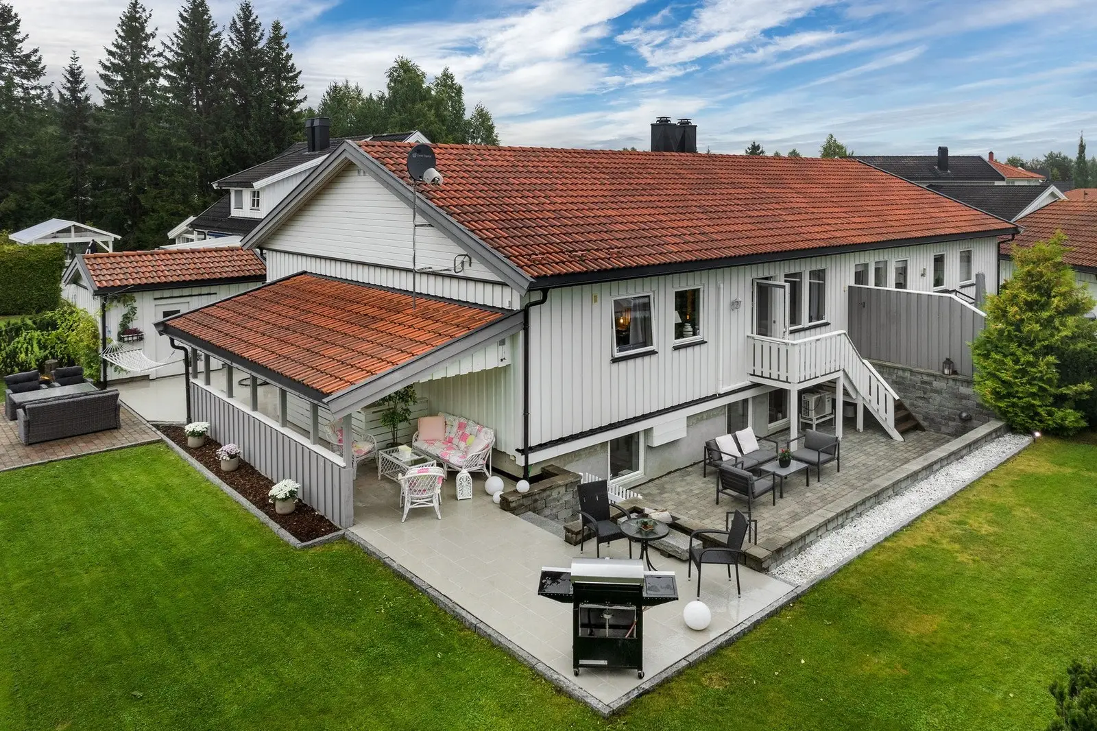 Eiendommen har en relativt flat og pent opparbeidet tomt med plen, beplantning og forstøtningsmurer. Hagen og platting m