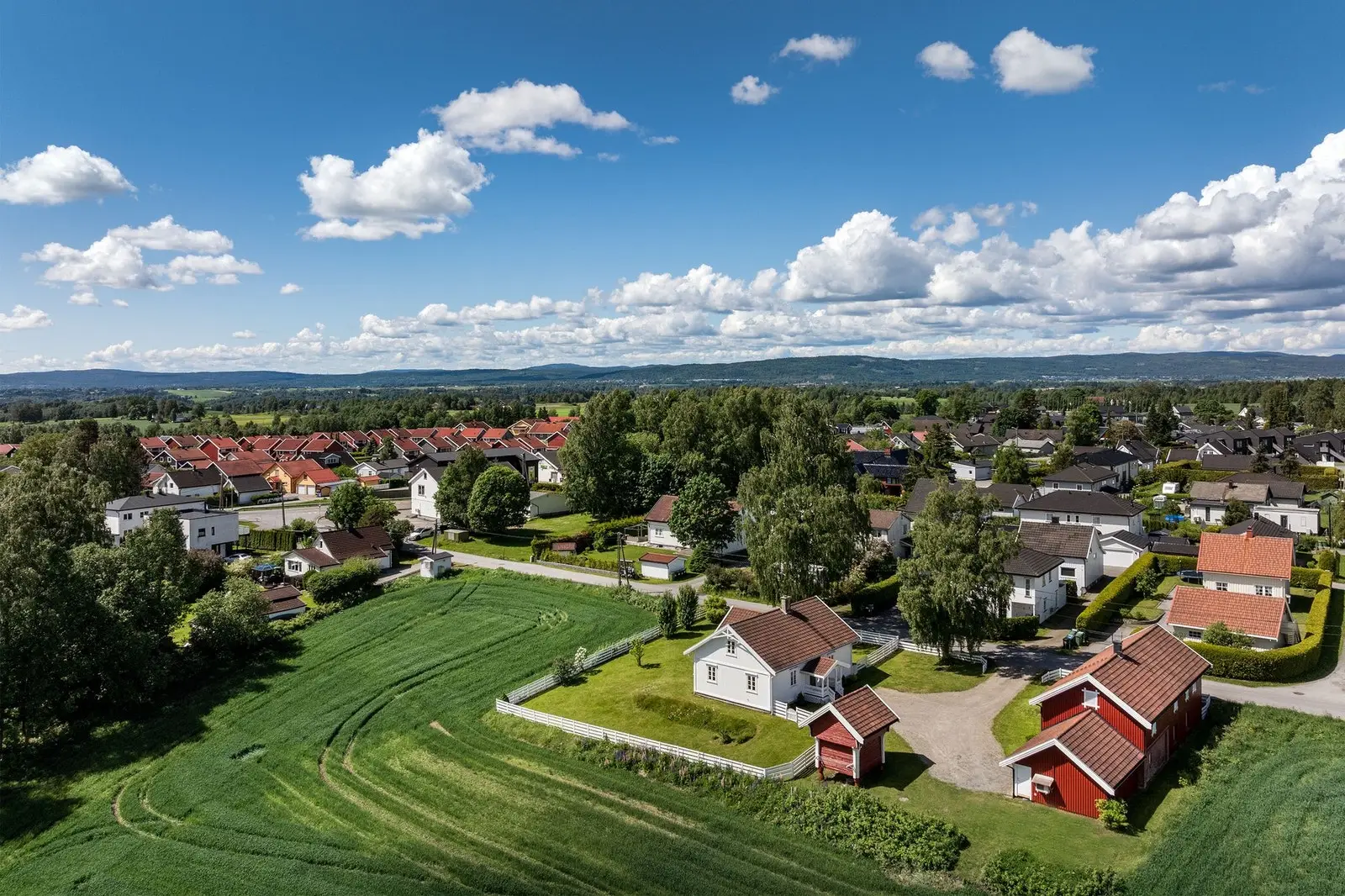 Eiendommen byr på 19,3 mål tomt med flott gårdstun, store grøntarealer og dyrket mark