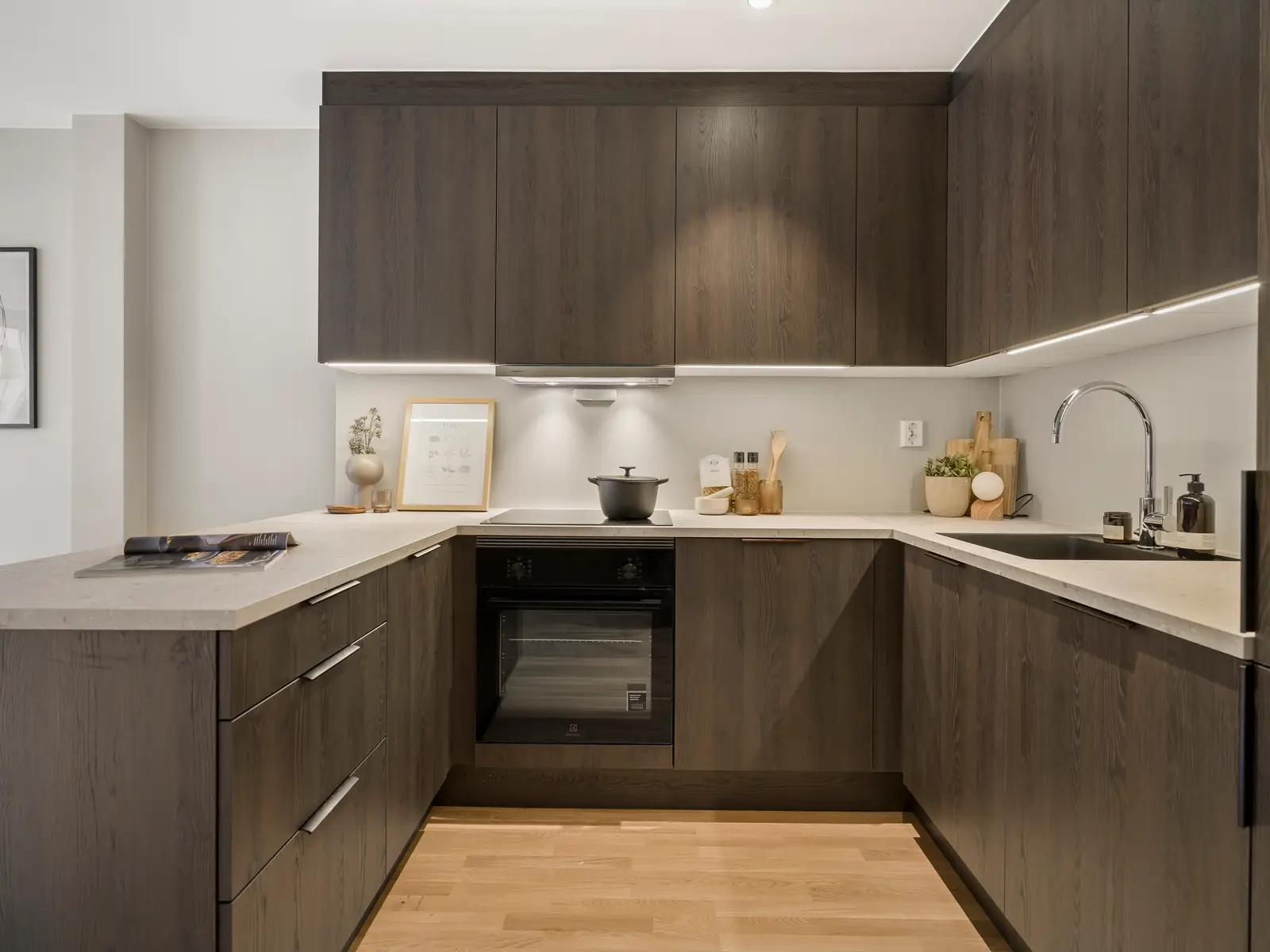 Kjøkkenet leveres fra HTH med moderne, slette beige fronter, laminert benkeplate i fargen sandsten og integrerte hvitevarer. NB! Bildet er a