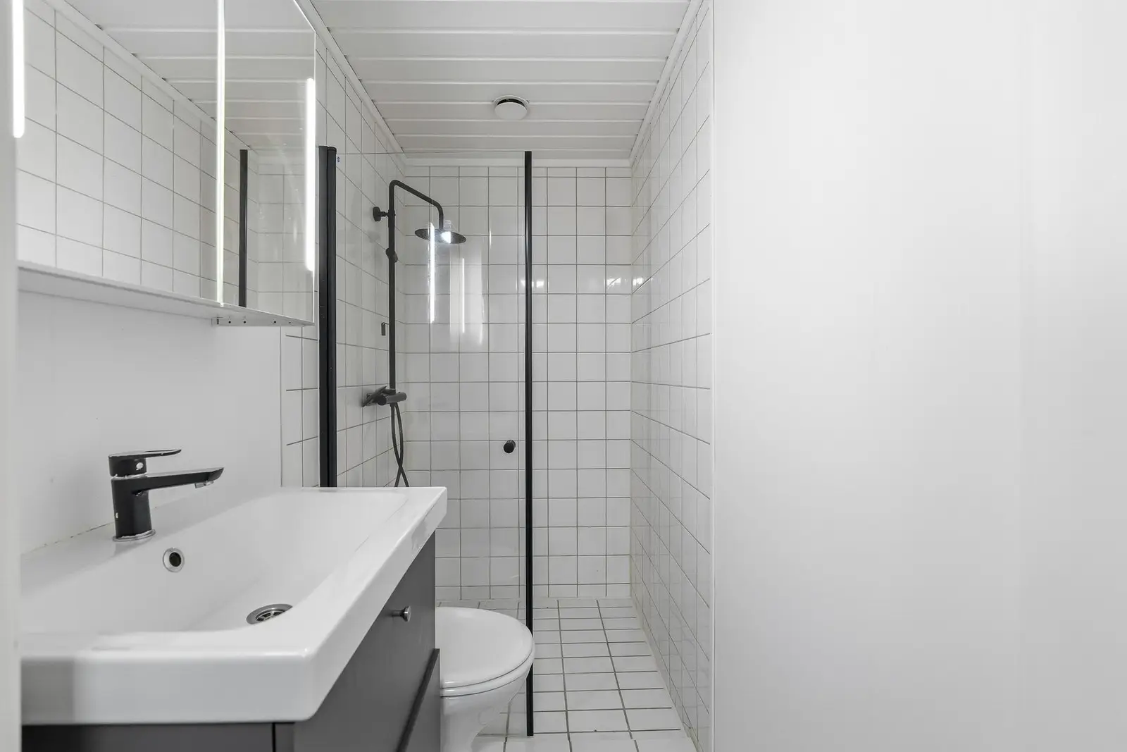 Badet har flislagt gulv med gulvvarme, fliser på vegger i våtsone og våtromsplater på øvrige veggflater.